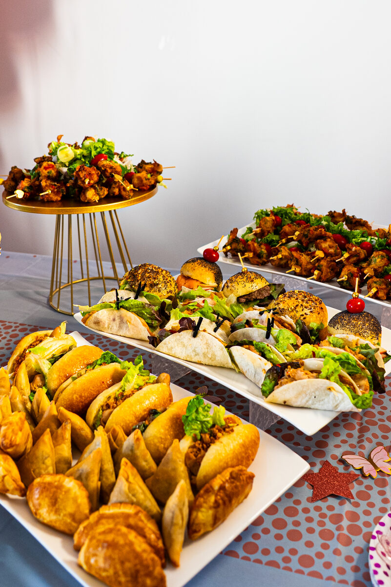 Gros plan sur des petits pains garnis et des bouchées colorées d'un buffet Kamyoo Délices