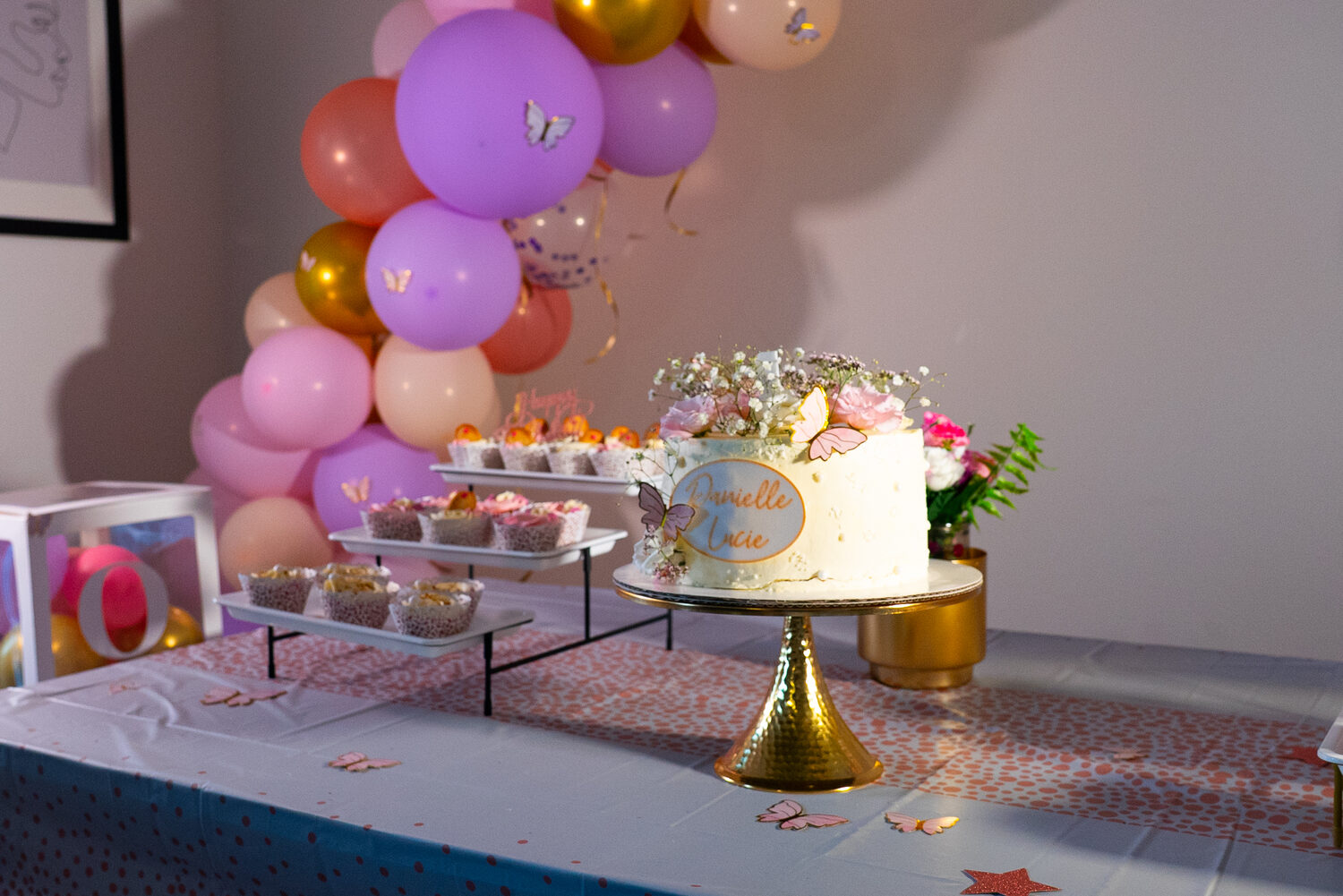 Petite fille émerveillée à côté de son gâteau d'anniversaire, un instant capturé par le photographe