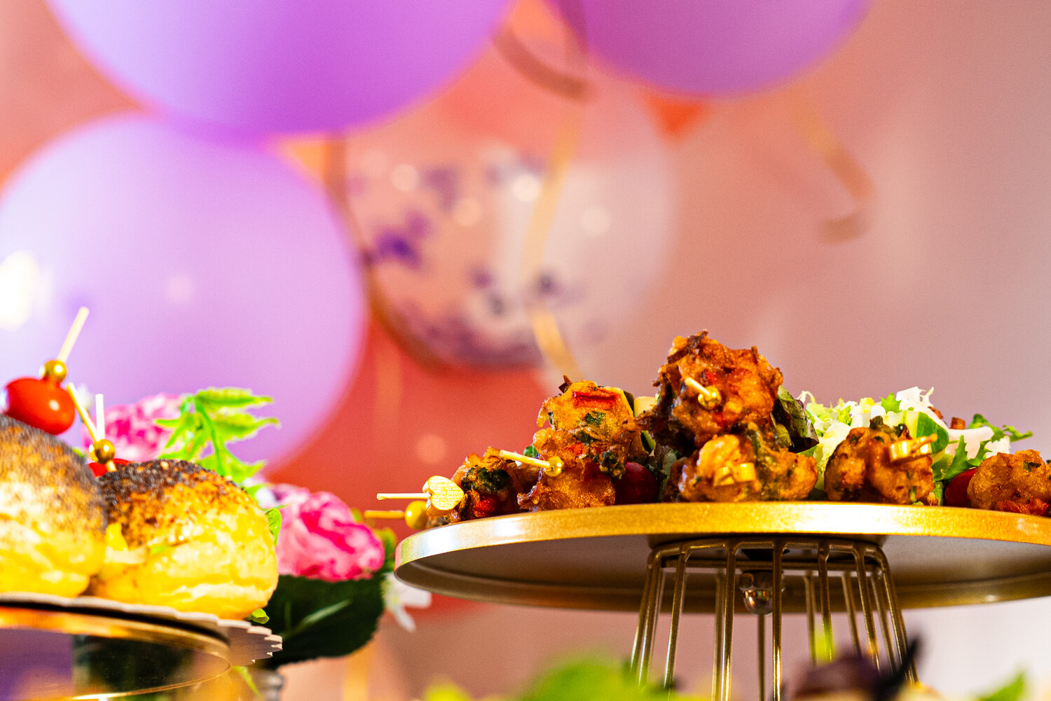 Buffet festif dressé devant une arche de ballons