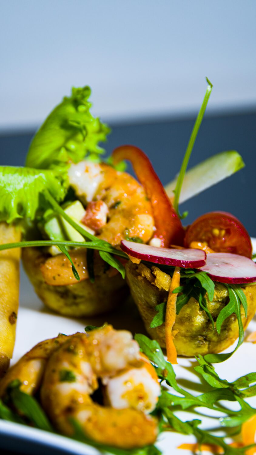 Gambas marinées, avocat, radis et roquette sur assiette raffinée